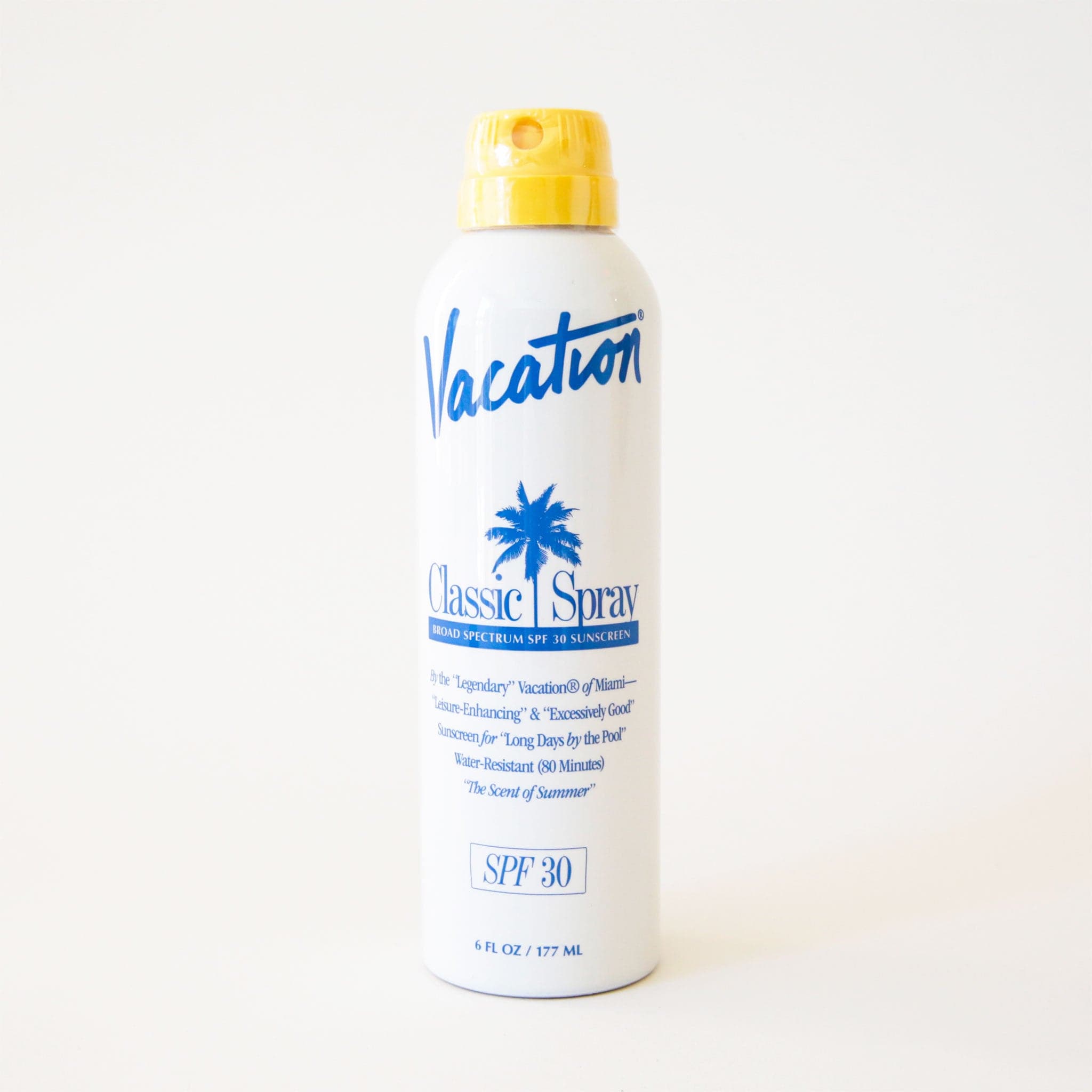 White glossy bottle of spray sunscreen. The bottle reads 'Vacation, Classic Spray, Broad Spectrum SPF 30 Sunscreen' in blue lettering. The bottle is complete with a yellow spray cap. 