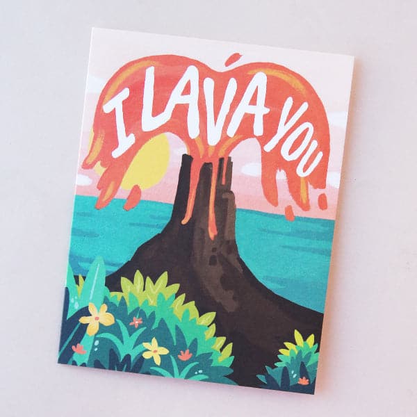 A card featuring an illustration of a tropical scene with the ocean in the background and a volcano erupting with red lava and white letters that read, " I Lava You".