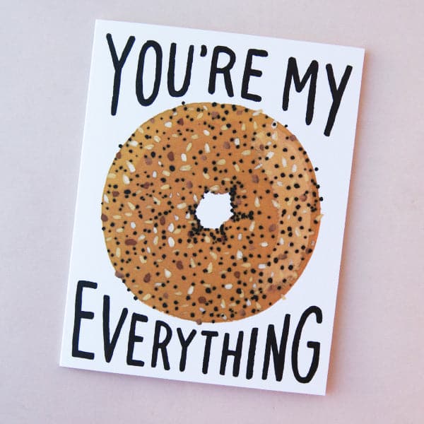 Idlewild Everything Bagel Folded Card - featuring a photograph of a white folded card with a graphic of an everything bagel along with &quot;You&#39;re My Everything&quot; in black text.