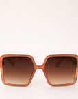 70's inspired square sunglasses with an oversized cognac colored frame and a brown lens.