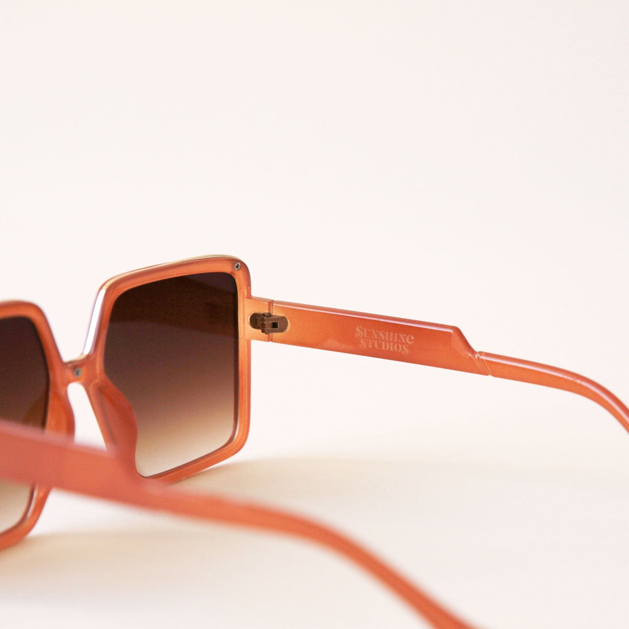 70&#39;s inspired square sunglasses with an oversized cognac colored frame and a brown lens.