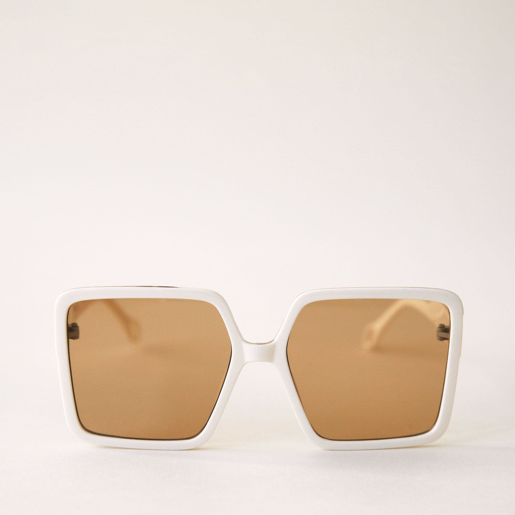 70's inspired square sunglasses with an oversized white frame and amber colored lenses.