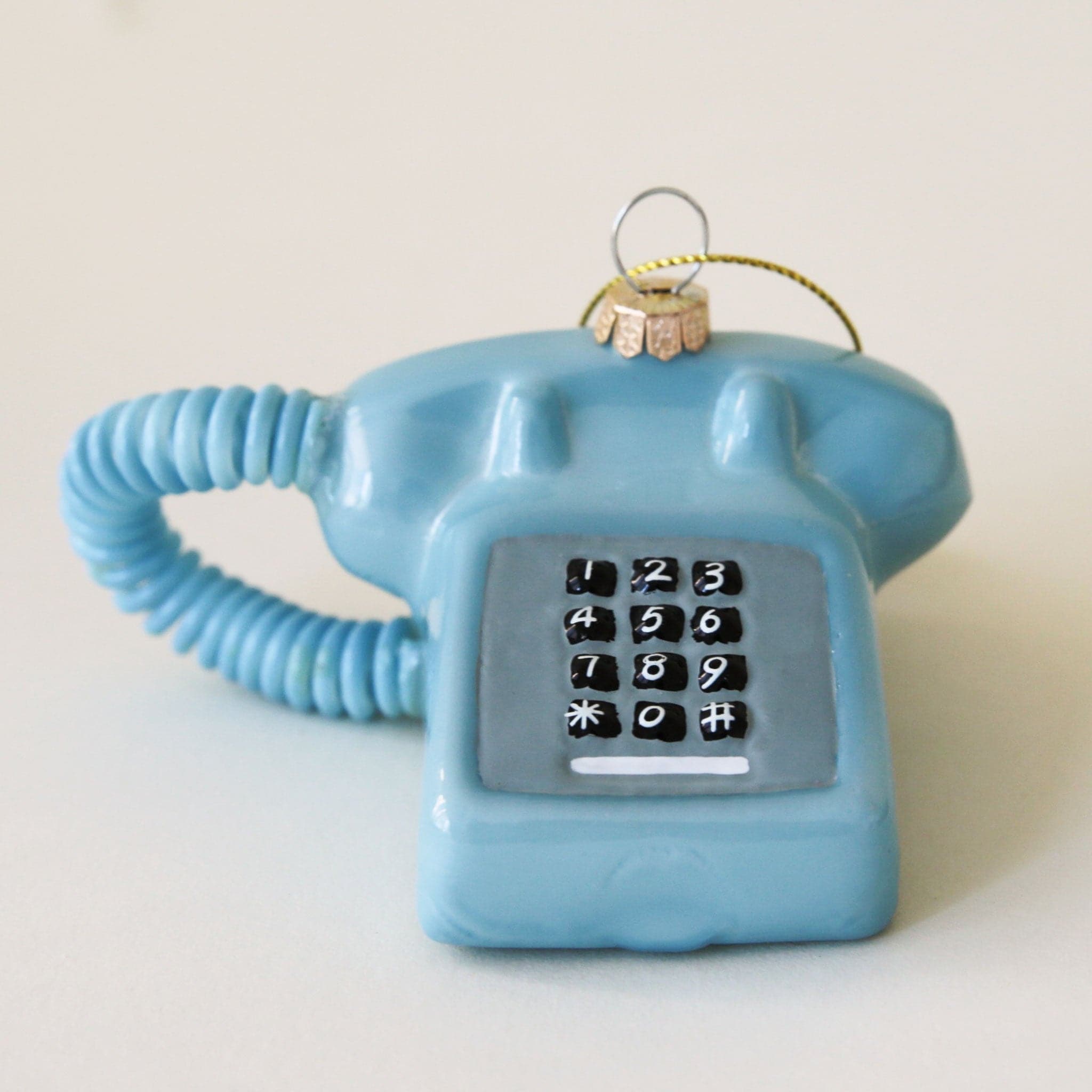 A glass touch tone phone ornament in a shiny blue shade.