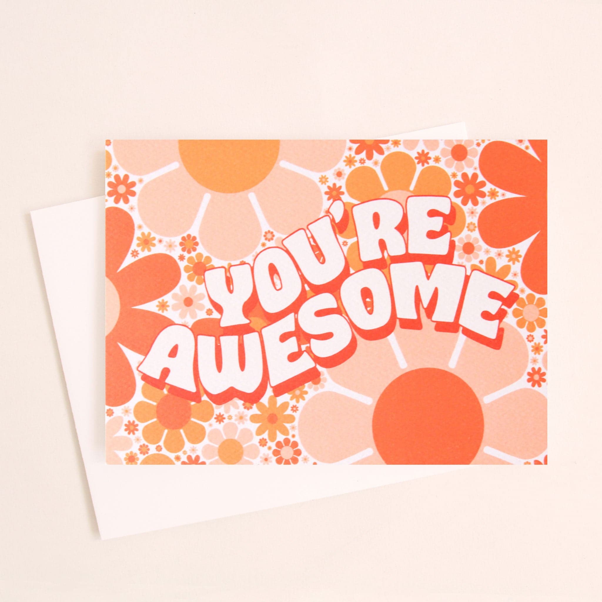 Card filled with orange and pink retro flower design. The car dreads &#39;you&#39;re awesome&#39; in white curved bubble lettering with tangerine orange shadow detailing. 