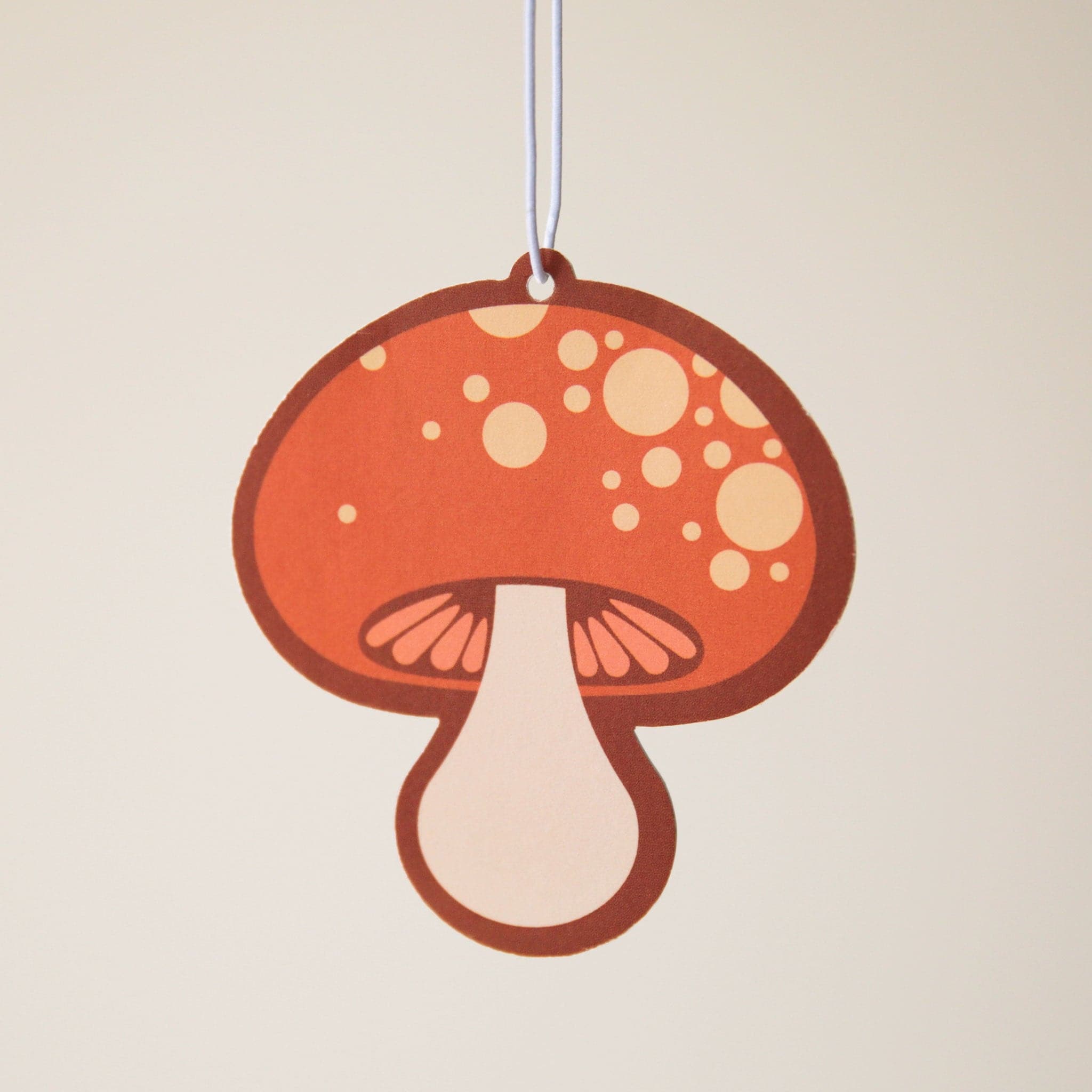 A brown-orange mushroom shaped air freshener with small dots on the top.