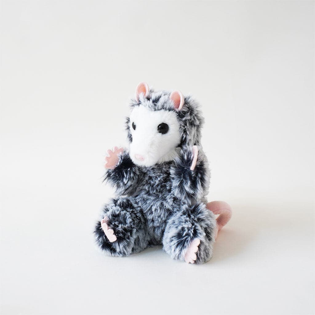Excessively cute stuffed baby possum covered in ashy fur with frosted tips and pale pink paws, ears, nose and tail. The possum has a solid white face and a pair of black, gleamy eyes. 