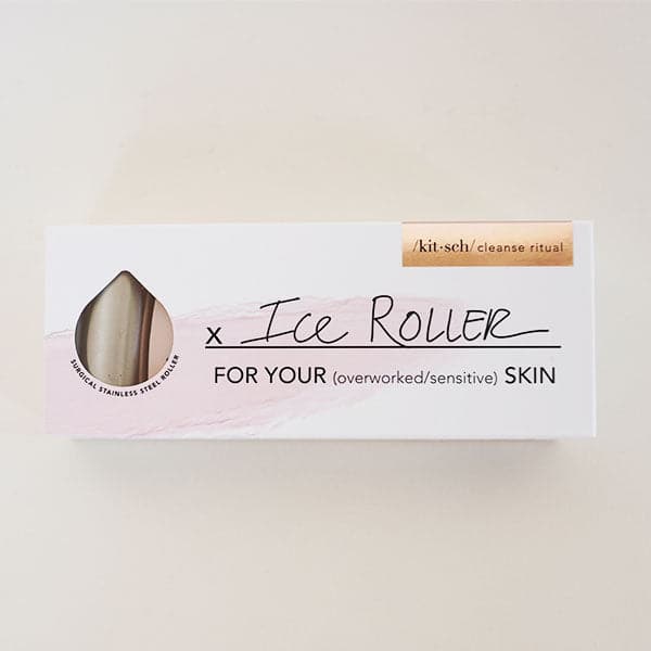 On a cream background is a white and light pink box that includes a facial ice roller for depuffing. 