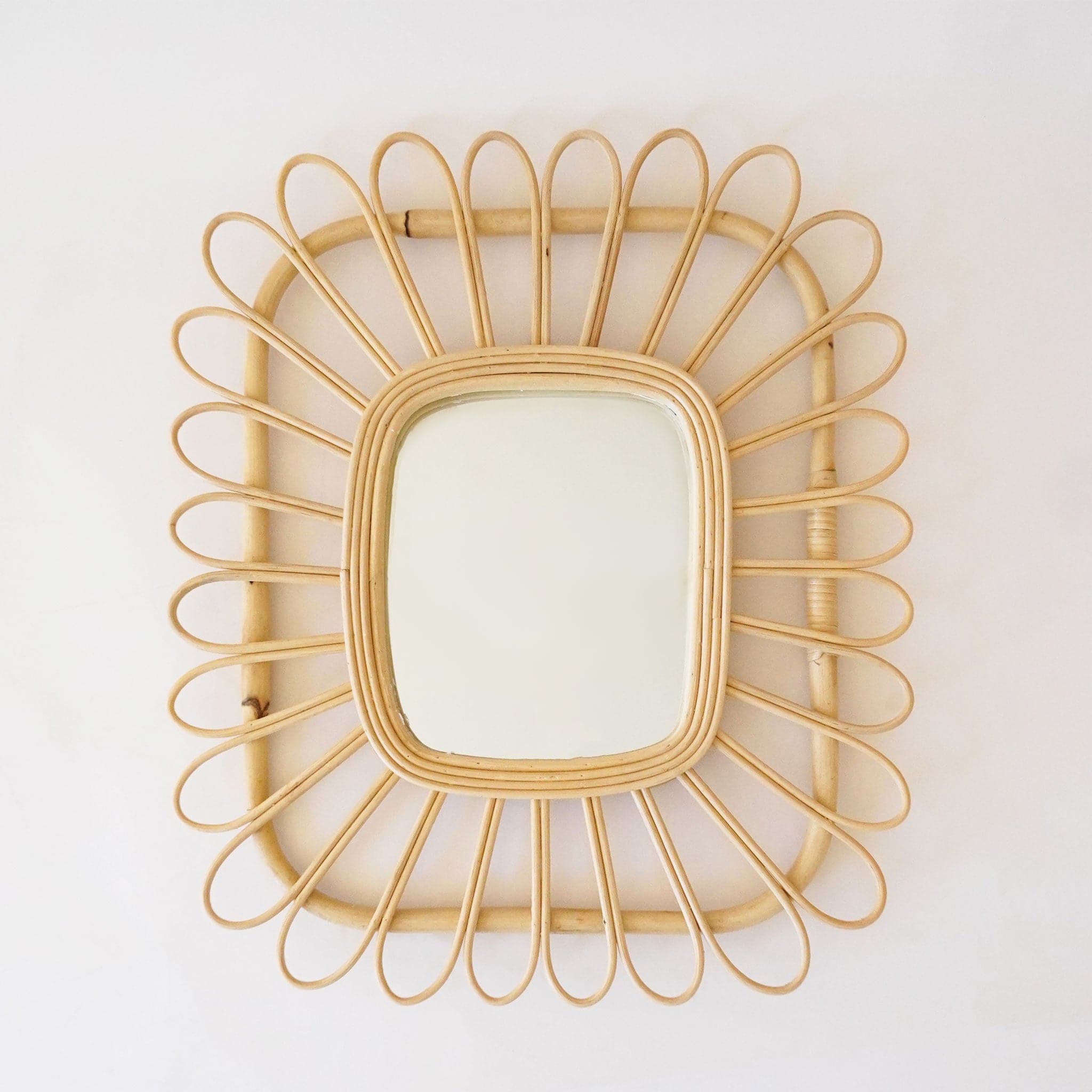Rectangle shaped mirror with a piped rattan design. 