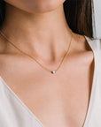 A dainty chain necklace with a circle white opal accented with a smaller CZ diamond set right beside it.
