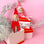 On a cream background is a elf ornament with long arms and legs with a pink suit and hat on as well as a pink string loop for hanging and photographed here next to the red version.
