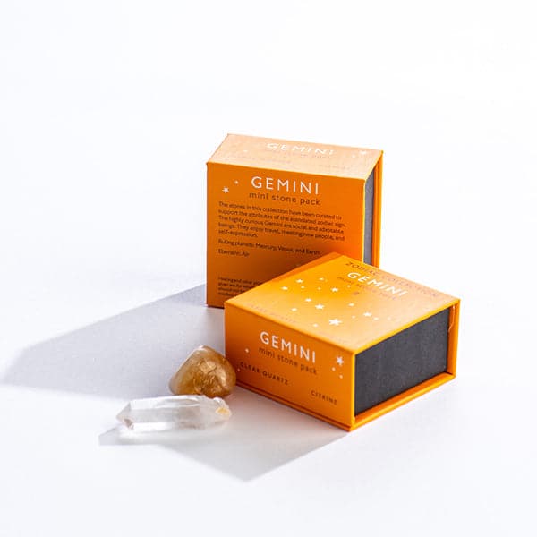 An orange magnetic box featuring the Gemini sign's mini stone pack. It includes a mini clear quartz crystal and tumbled citrine stone.