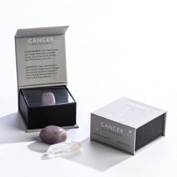 A grey magnetic box featuring the Cancer sign's mini stone pack. It includes a clear quartz crystal and a tumbled lepidolite stone.