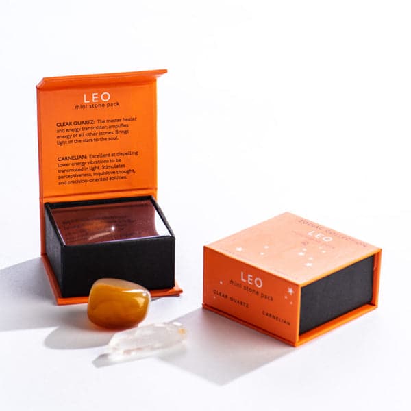 An orange magnetic box featuring the Leo's mini stone pack. It includes a clear quartz crystal and a tumbled carnelian.