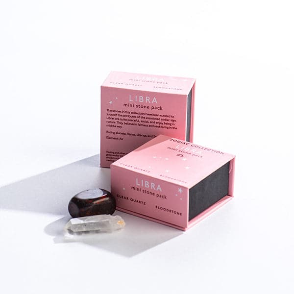 A pink magnetic box featuring the Libra&#39;s mini stone pack. It features and clear quartz crystal and a tumbled bloodstone.