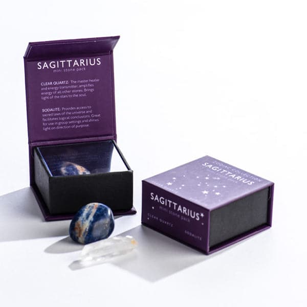 A purple magnetic box featuring the Sagittarius&#39; mini stone pack. It includes a clear quartz crystal and a tumbled sodalite stone.