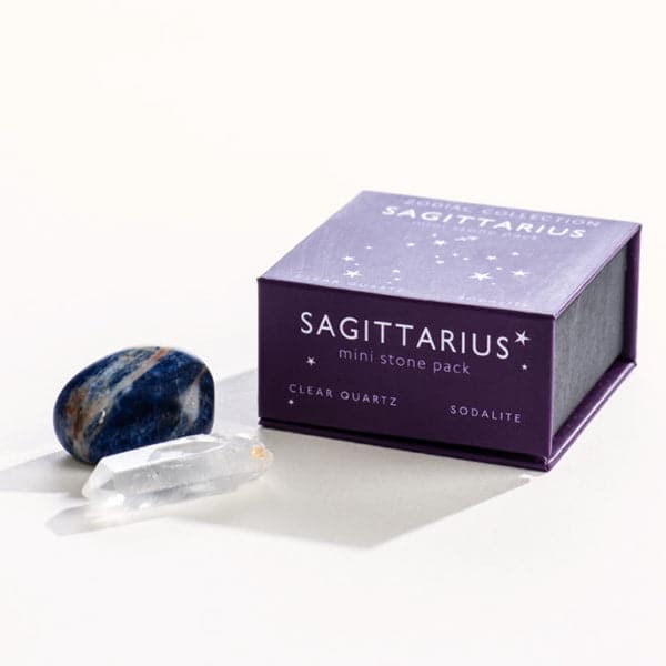 A purple magnetic box featuring the Sagittarius&#39; mini stone pack. It includes a clear quartz crystal and a tumbled sodalite stone. 