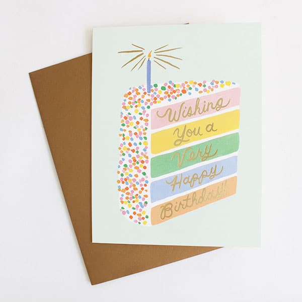 On a white background is a super light mint card with a multicolored pastel birthday cake slice graphic with multicolored sprinkles on the edge, a sparkling candle and different colors in each layer with words that read, "Wishing You a Very Happy Birthday" in gold letters. 