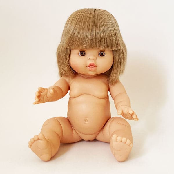 Baby girl doll with blonde bob haircut without clothes against white background.
