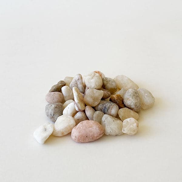 On a cream background is an assortment of natural tan and cream colored stones.