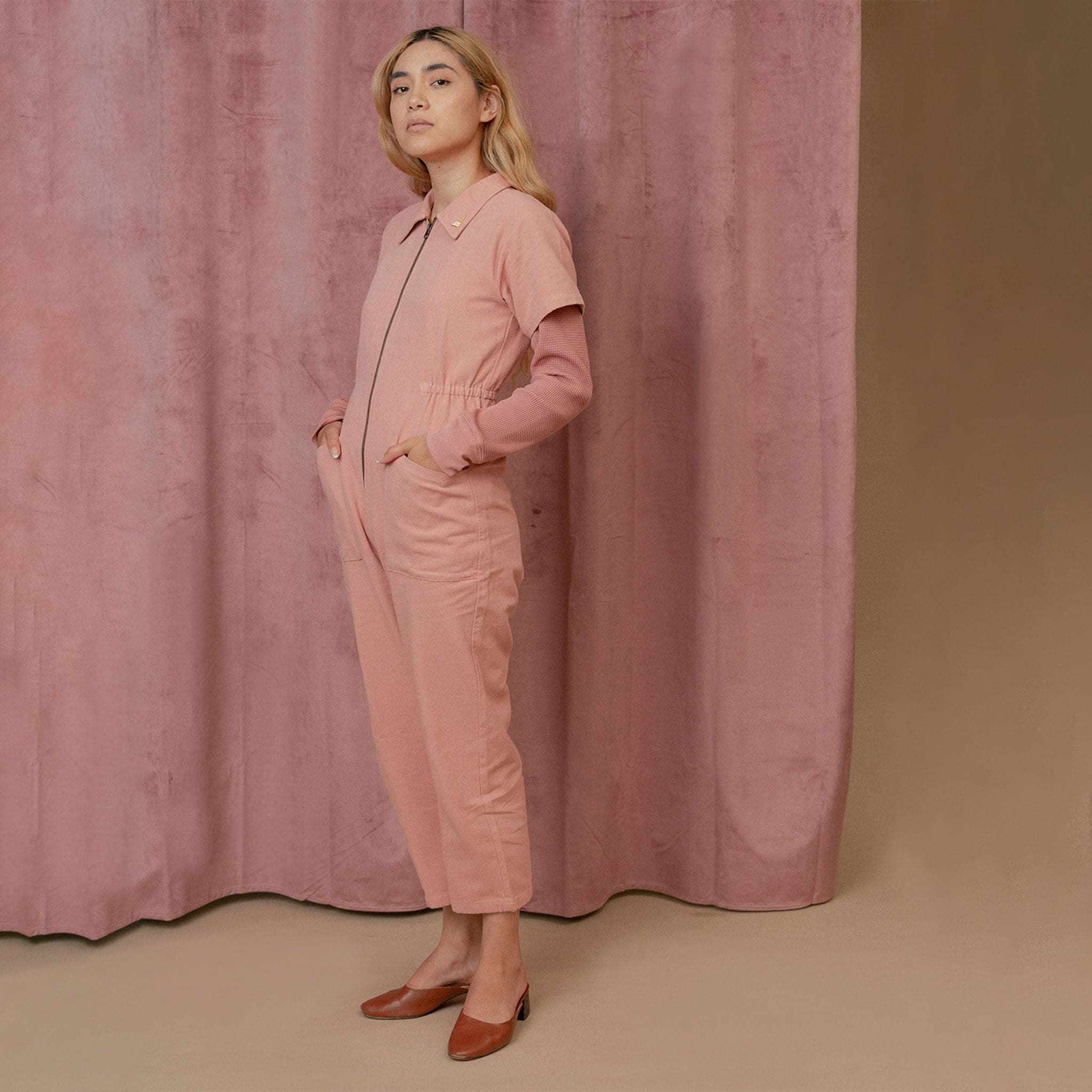 A short sleeved utility jumpsuit in the sweetest dusty rose shade. There is a front zipper and a two pockets.