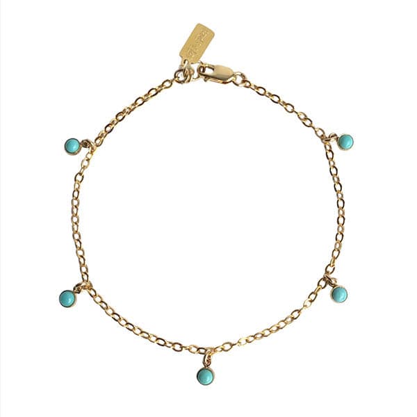 In front of a white background is a thin gold chain bracelet. The bracelet has five circle turquoise stone charms.