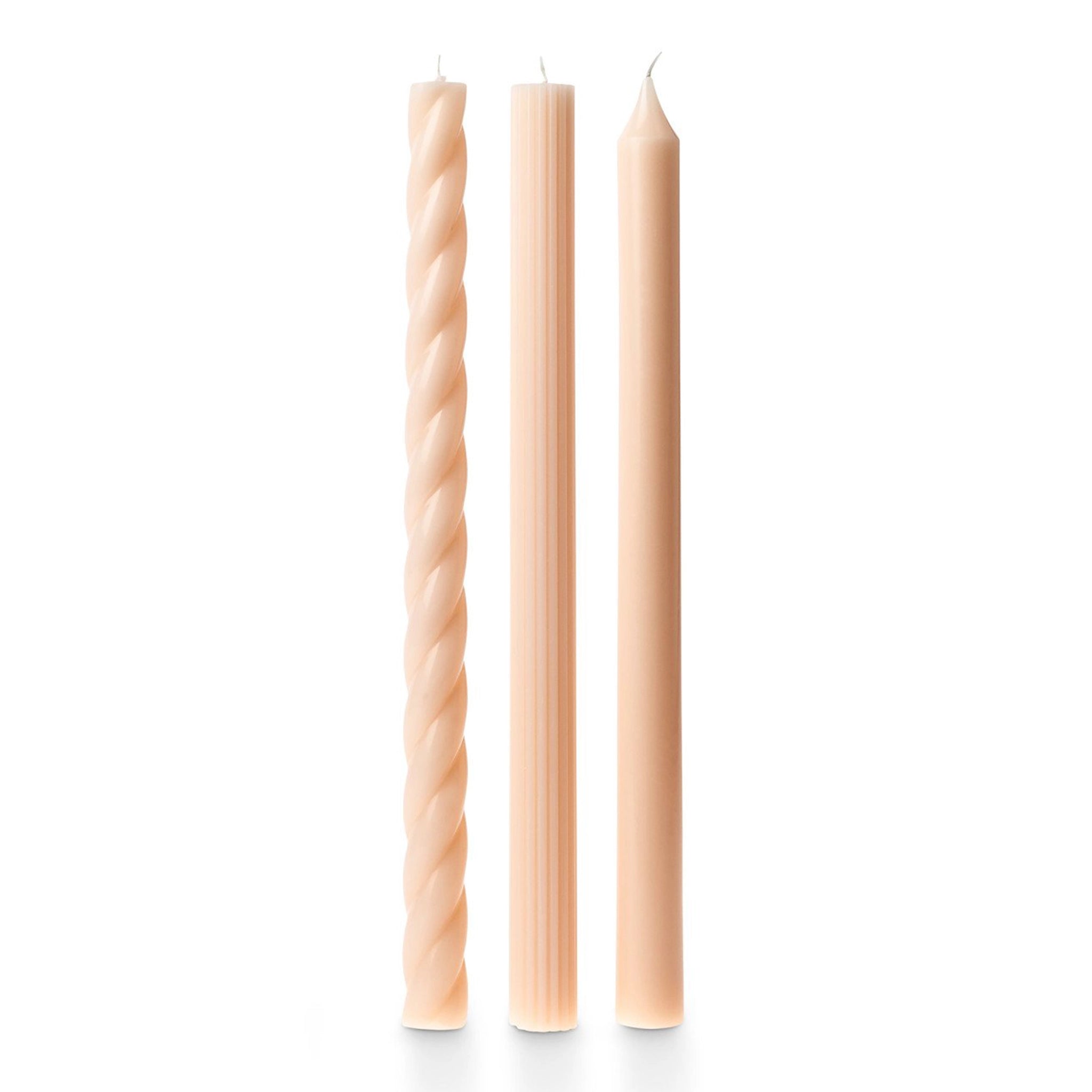 A photo of three off white tapered candles. There are three different styles, one twisted, one vertically ribbed and the other smooth.