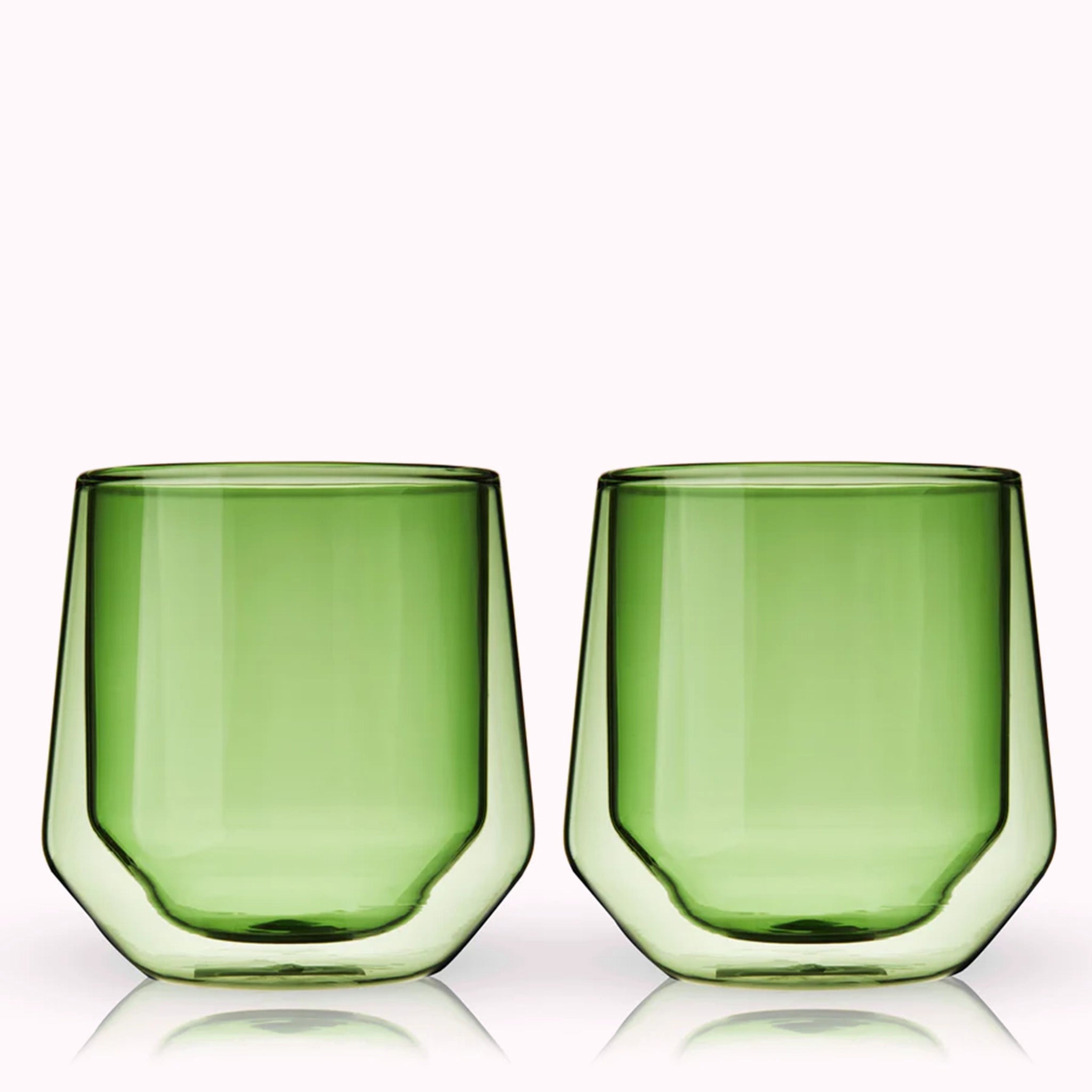 A set of two double walled glass tumbler cups in a green color photographed in front of a white background.