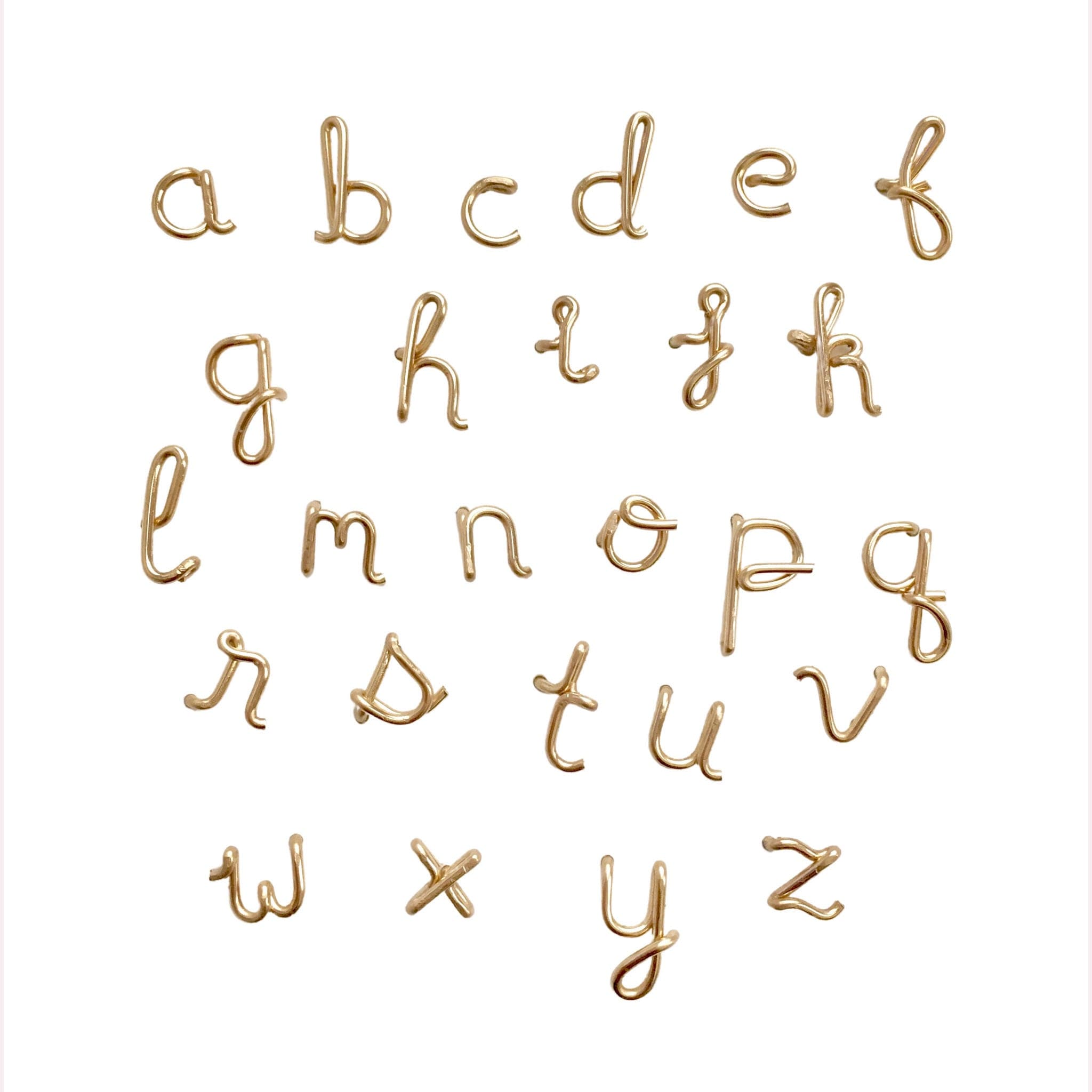 Individual stud earrings of gold wire bent into the shape of lowercase letters. Shown is letters A to Z.
