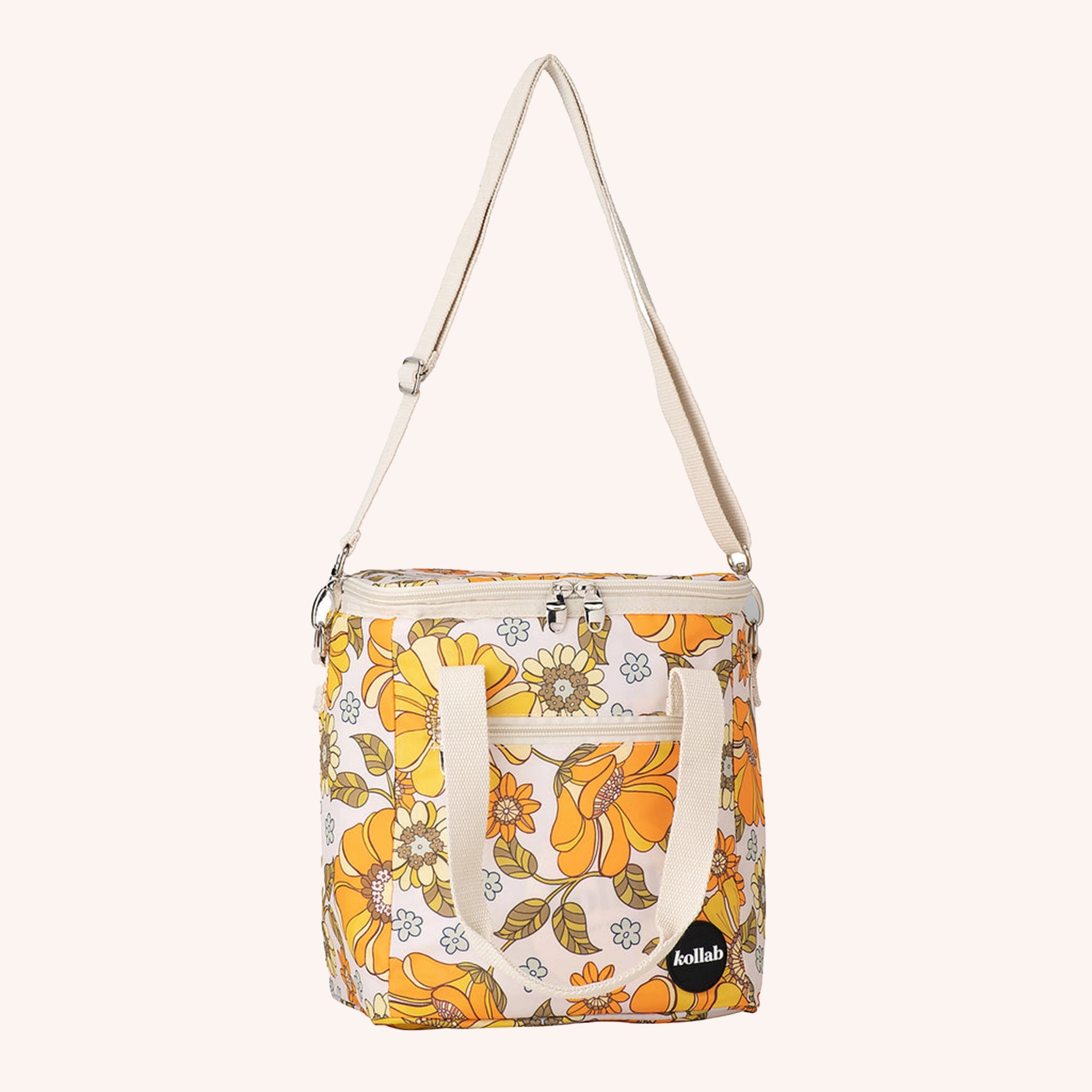 Photographed in front of a yellow background is a mini cooler with a cream adjustable strap and 70's style yellow and orange floral print.