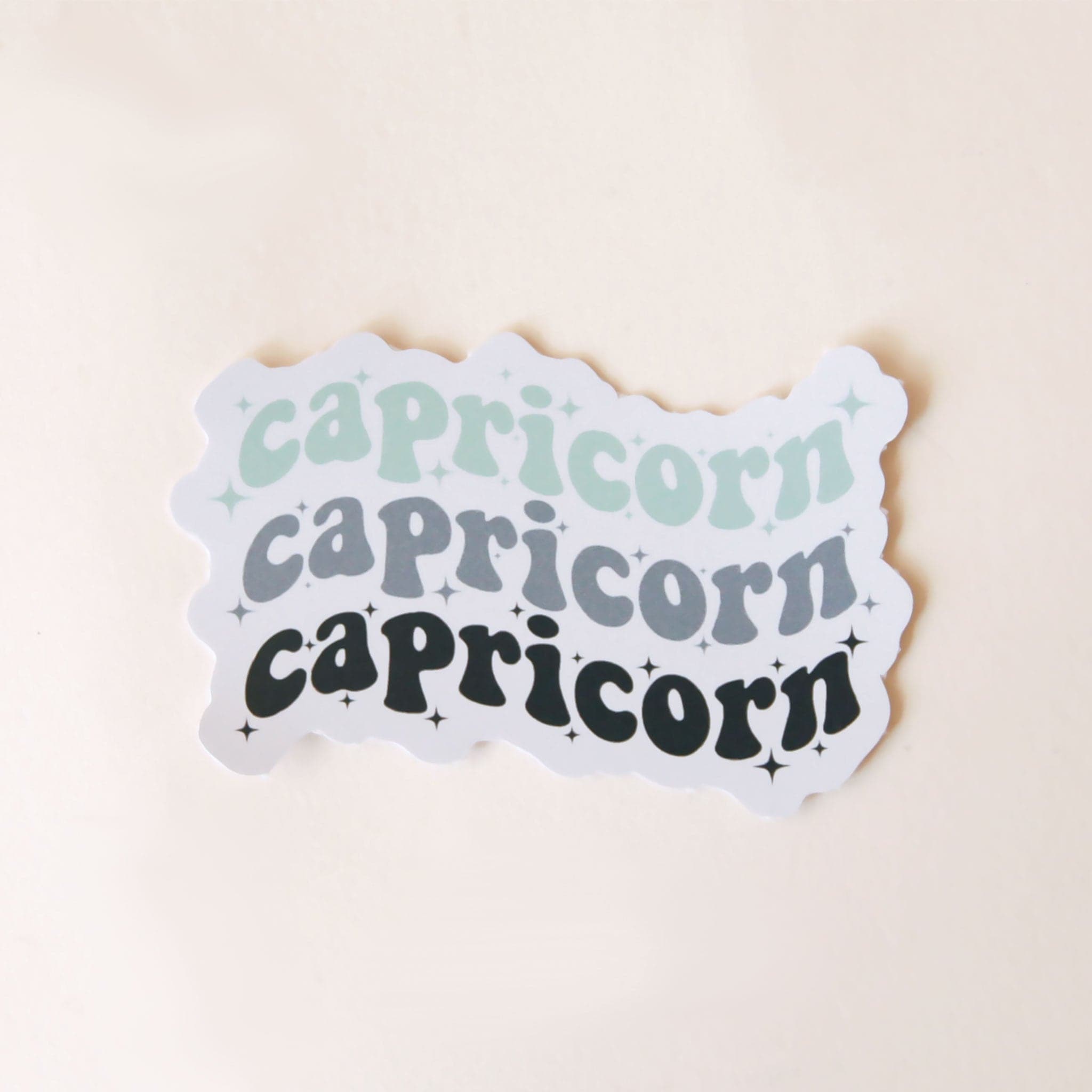 On a white background is a vinyl sticker with the word, &quot;Capricorn&quot; stacked on top of itself three times. 