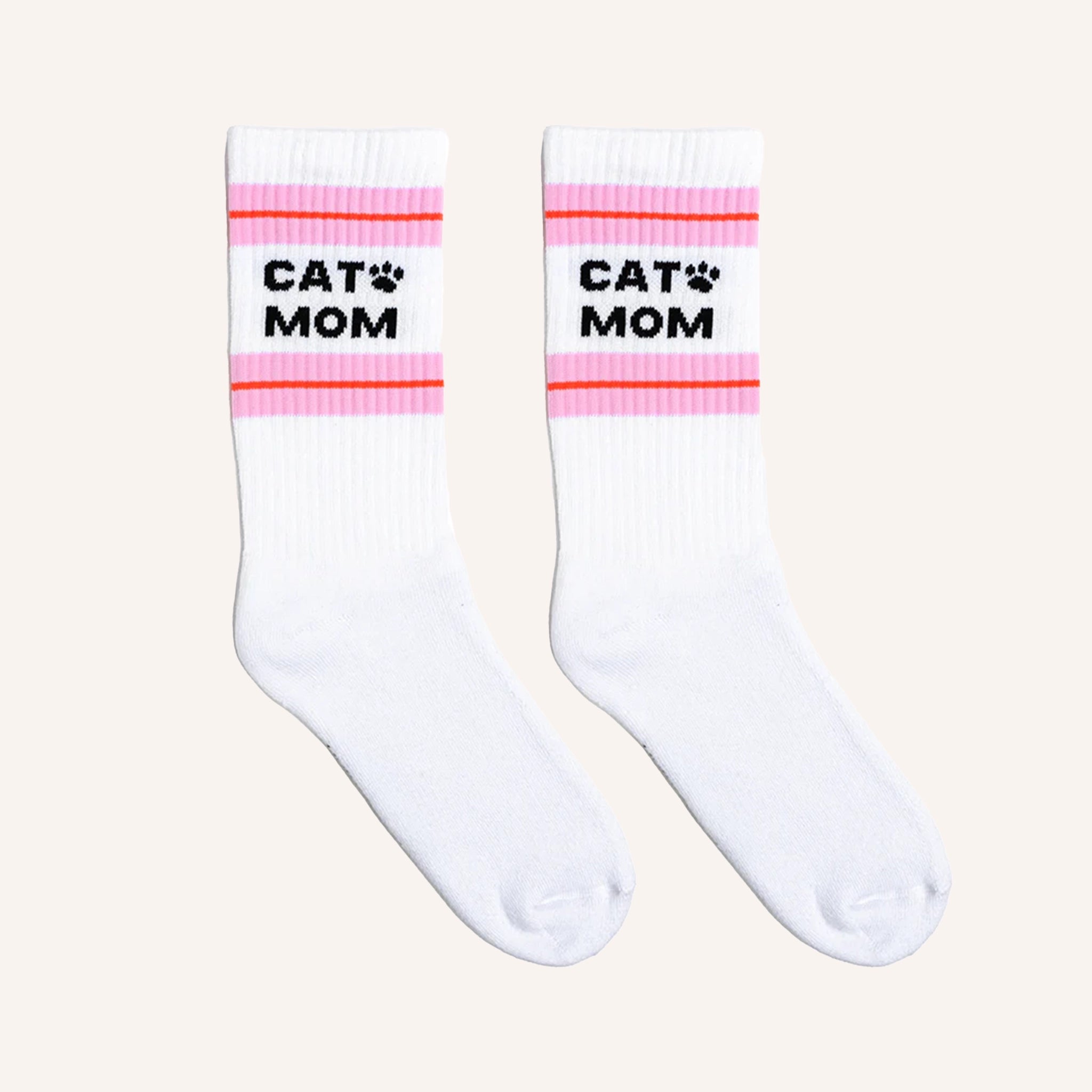 White crew socks with a pink and red striped design at the top along with black text that reads, "Cat Mom" as well as a small black paw print next to the word "cat".