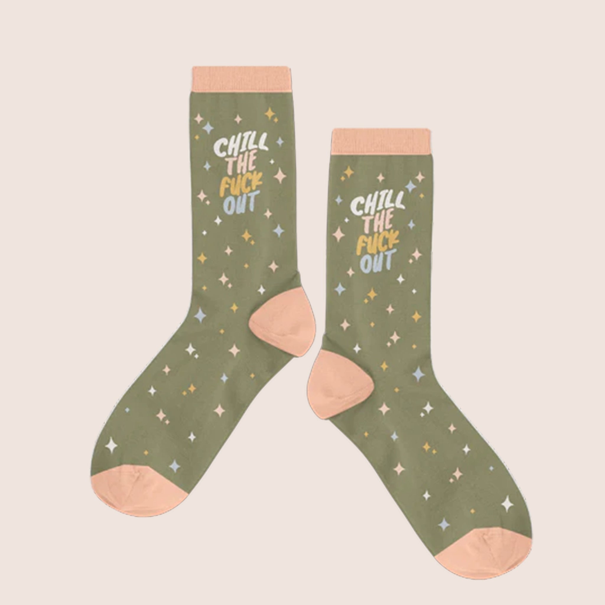 A pair of olive green crew socks with a peach border at the top and on the feet and heel as well as a diamond design all over in shades of cream, light yellow and light blue as well as text that reads, "Chill The Fuck Out" in the same color ways.