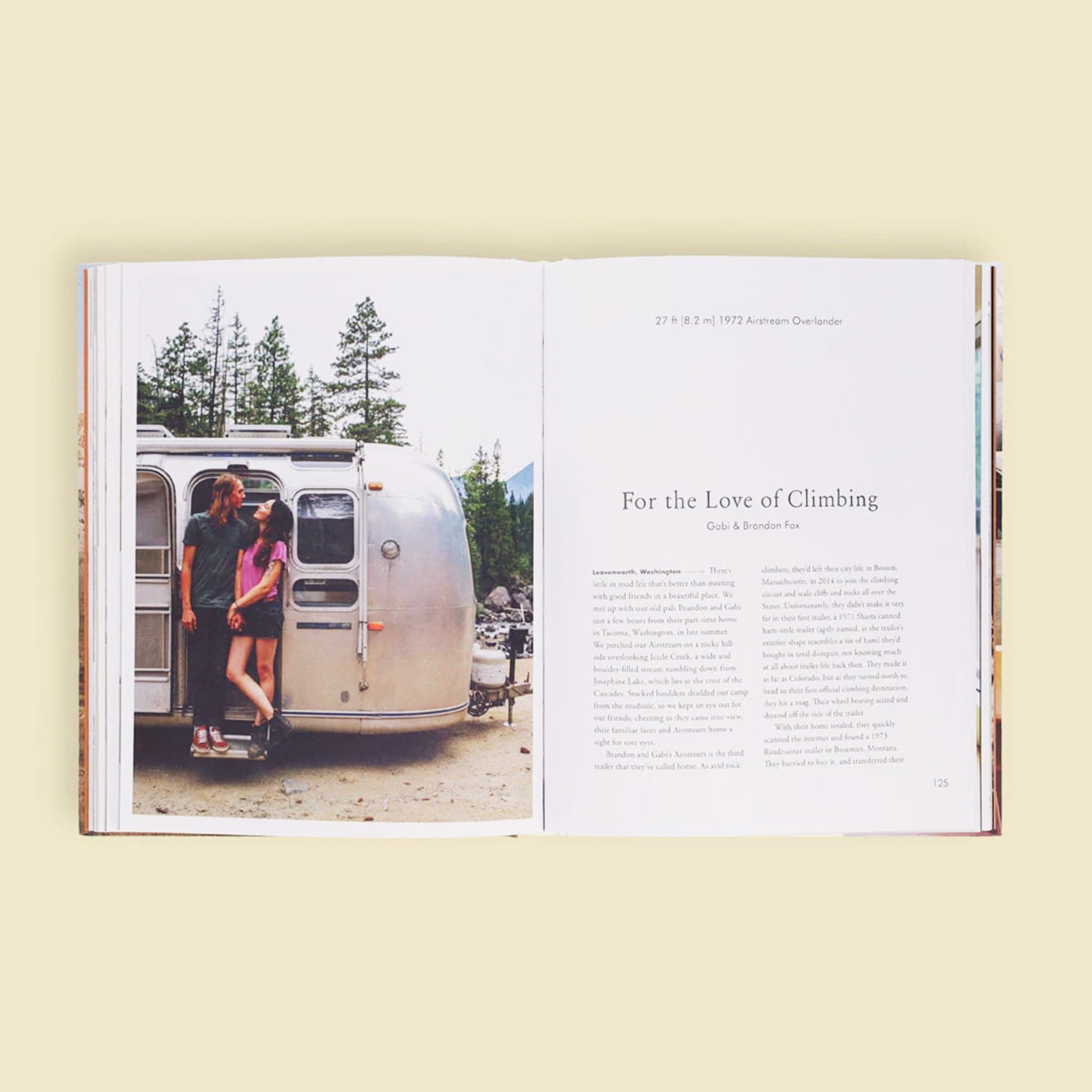 Two open pages of the book. The left page is filled with a lovely couple posed in front of their silver airstream trailer. The right page is titles &#39;For the Love of Climbing&#39; and dives into the story of Gabi and Brandon Fox against a solid white page.