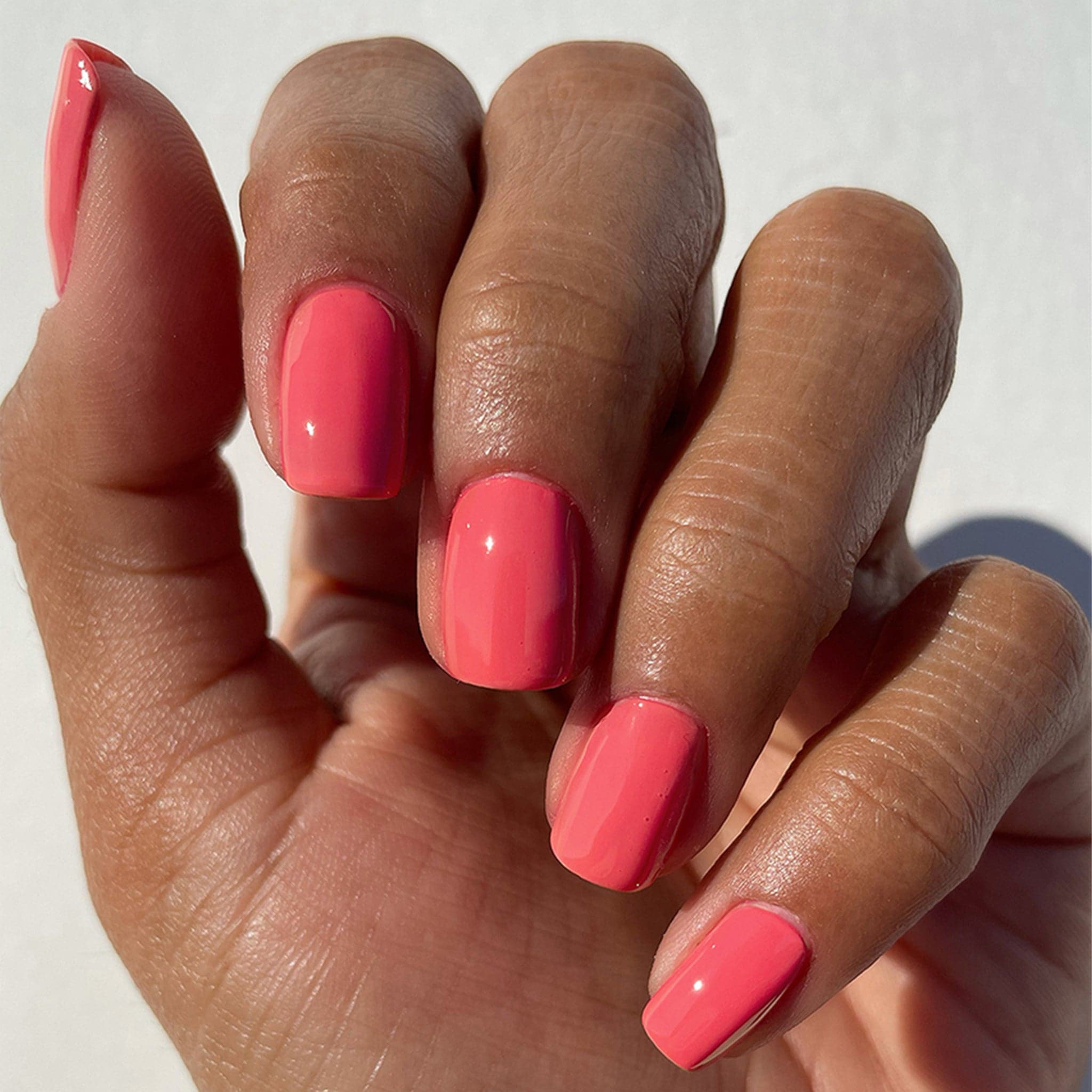 Hand modeling Cirque Color&#39;s Bam Nail Polish. The polish color is a flamingo pink.