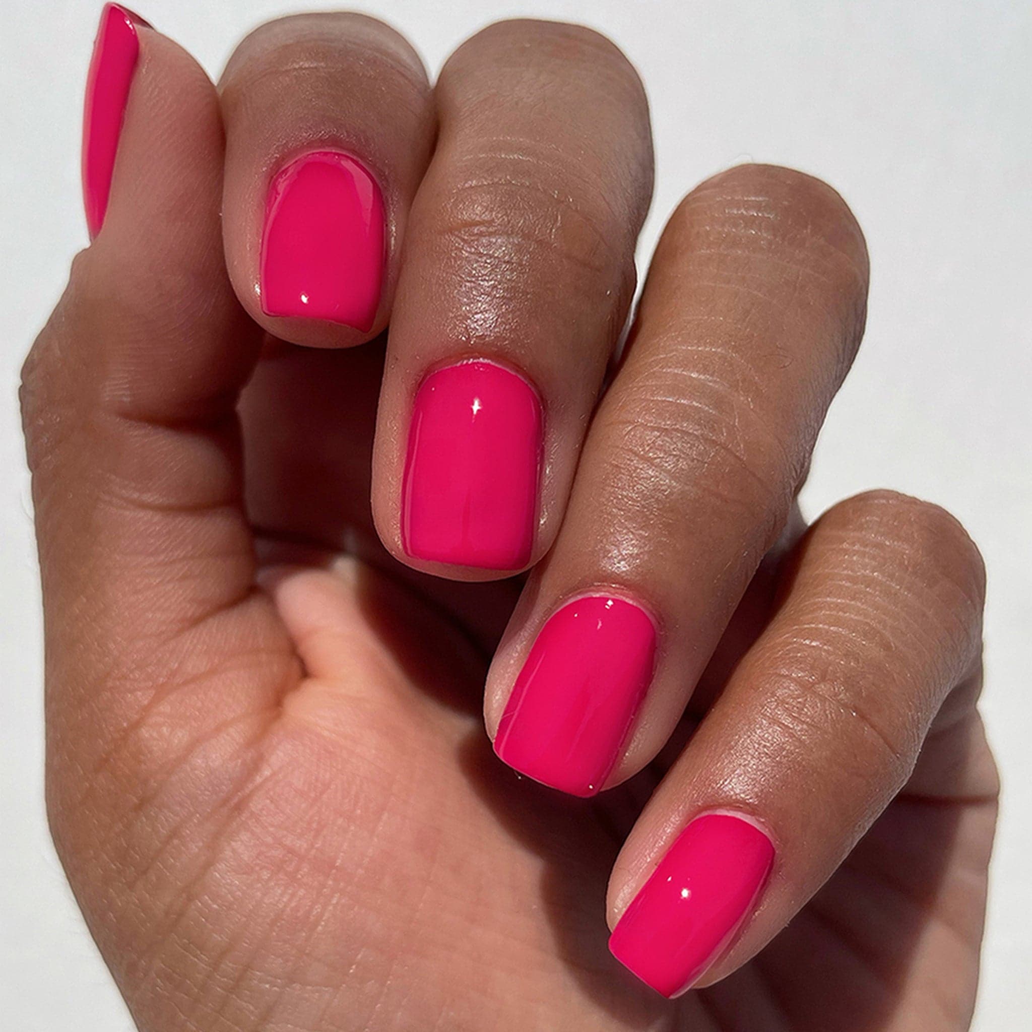 The hot pink nail polish worn on a models nails. 