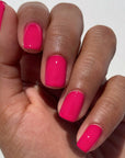 The hot pink nail polish worn on a models nails. 