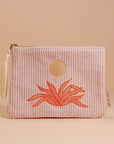 A light pink corduroy pouch with a sun and an orange aloe plant graphic in the center. The pouch has a single zipper going across the top.