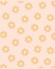 A light blush cotton blanket with a repeating mustard yellow daisy print.