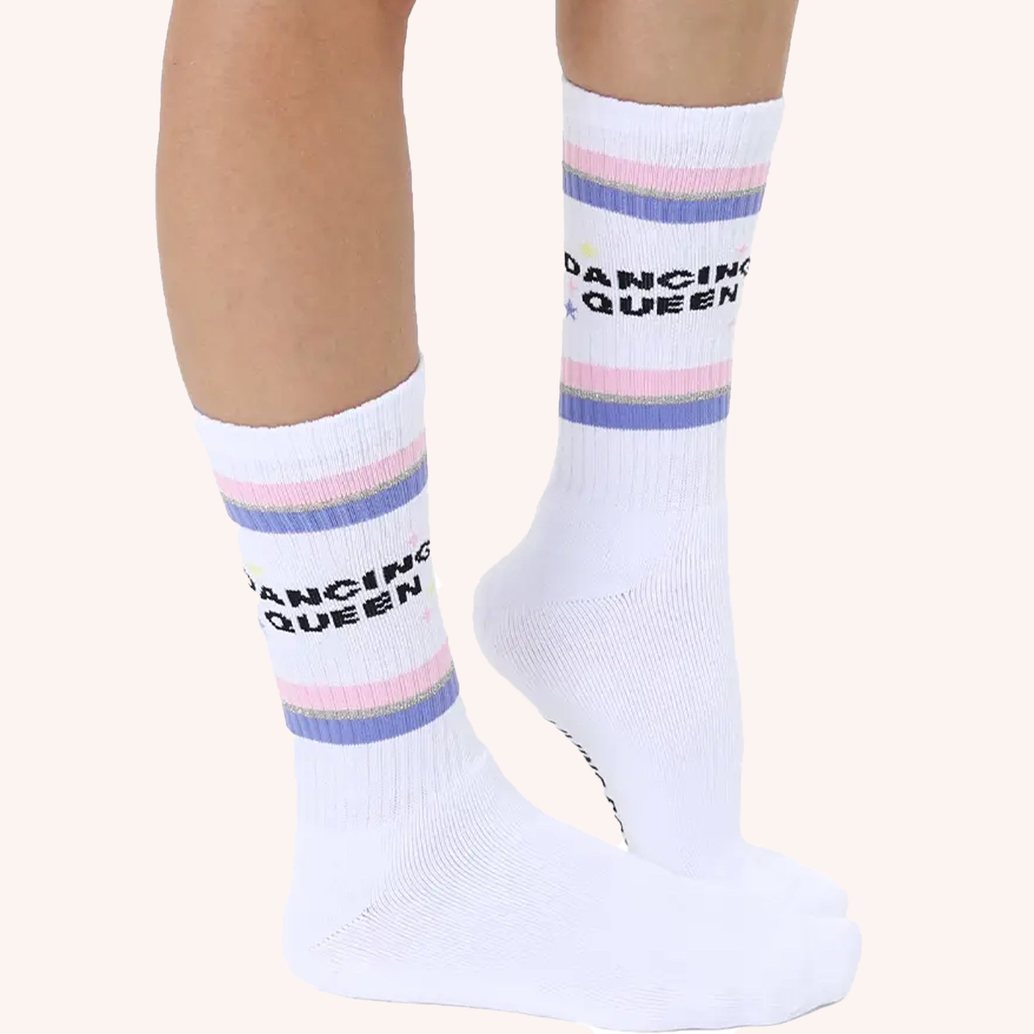White crew socks photographed on a model with black text that reads, "Dancing Queen" along with a pink and purple stripe above and below. 