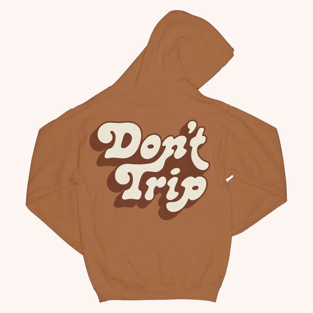 A brown vintage washed hoodie with the words "Don't Trip" on the back.