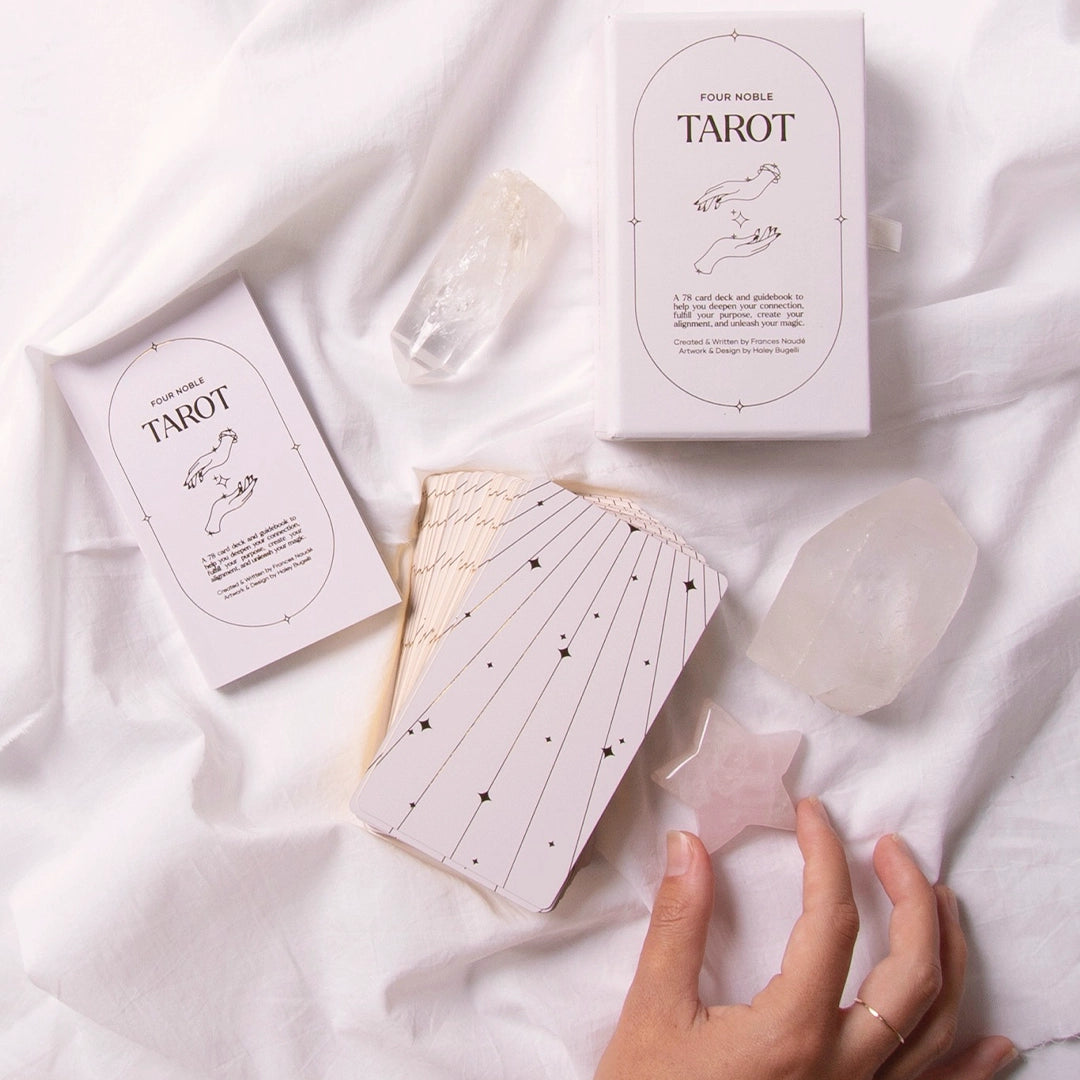 A cream box of 78 Tarot cards with an illustration of two hands and a star in between. All cards are beautifully illustrated with descriptions underneath and detailed with gold foiling.