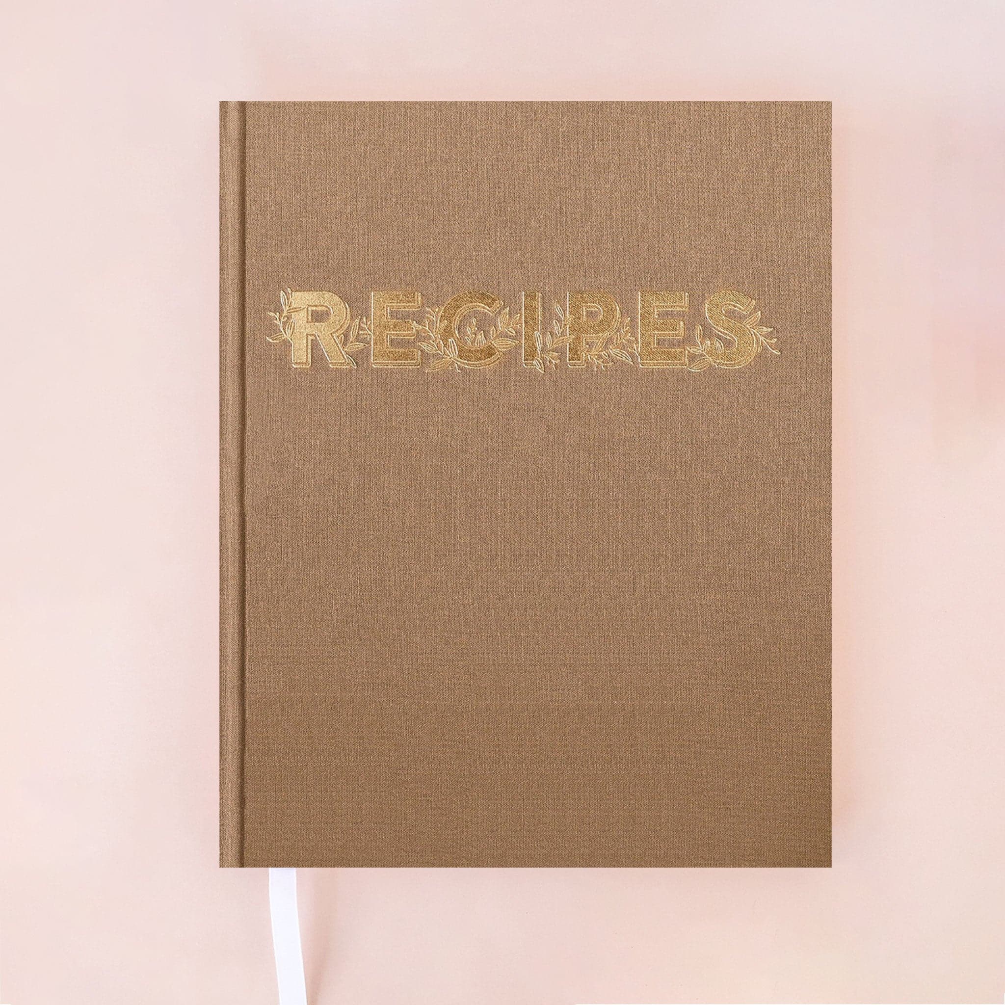 A latte brown recipe notebook that reads, "Recipes" in gold text with gold vine detailing around the letters.