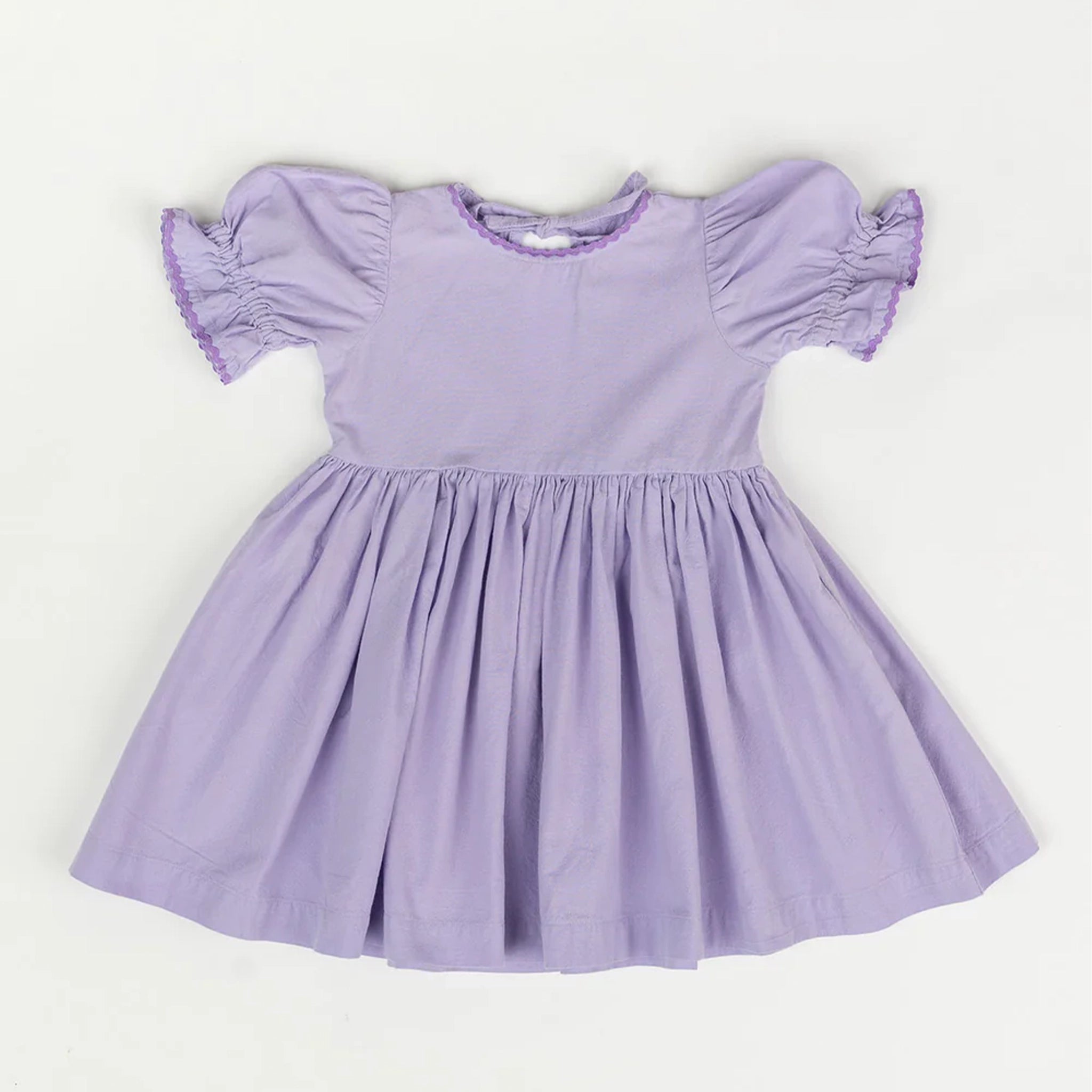 A lavender baby doll style dress with puff sleeves and a flowy skirt laying flat on a white background. 