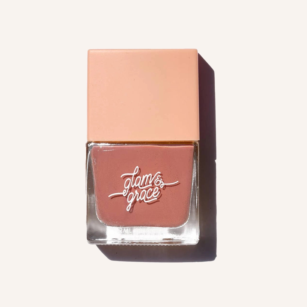 A rosie nail polish with a satin finish in a glass bottle with a peachy square lid.