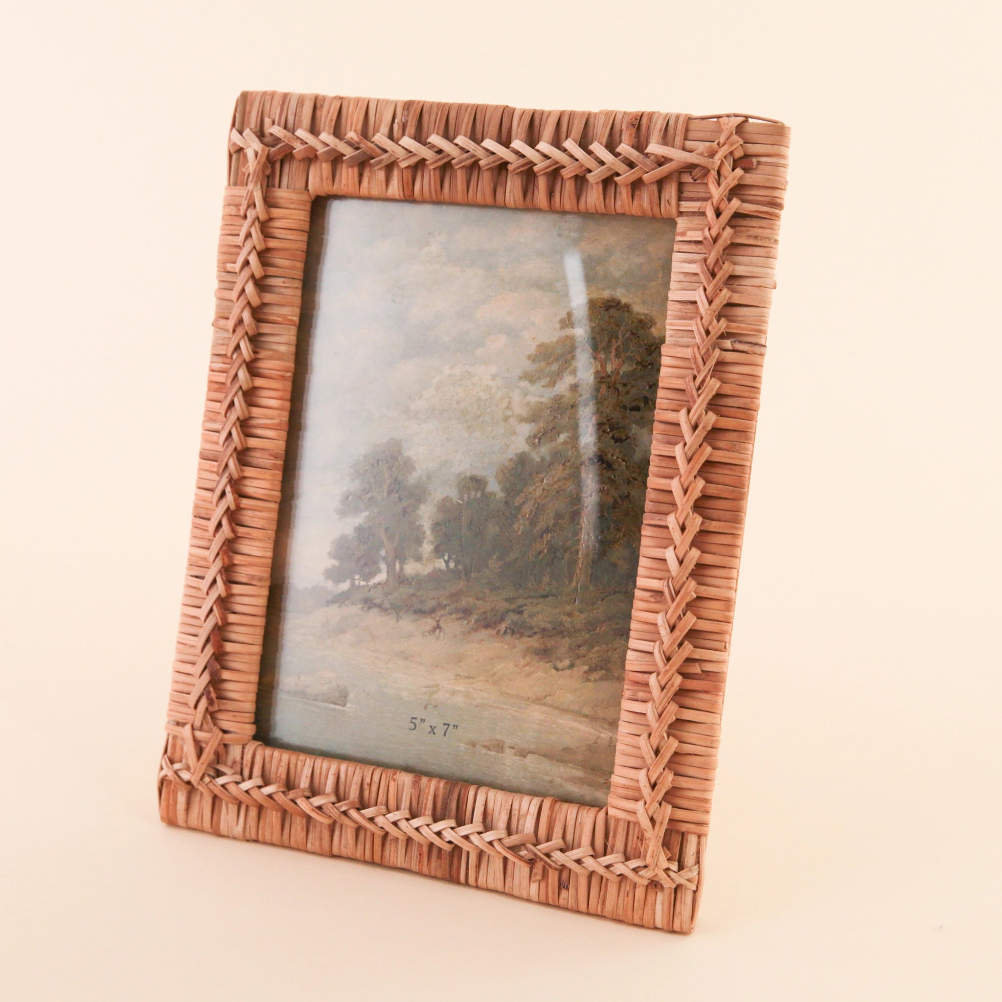 A 5" x 7" hand woven rattan frame a natural brown shade detailed with intricate stitching int he center.