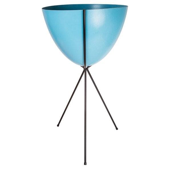 In front of a white background is a bright blue colored bullet planter. The planter has a wide top and narrows at the bottom. The planter is held up by a black metal stand. The stand has three black metal legs.
