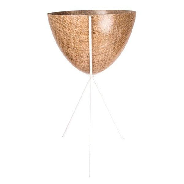 In front of a white background is a wood colored bullet planter. The planter has a wide top and narrows at the bottom. The planter is held up by a white metal stand. The stand has three white metal legs.