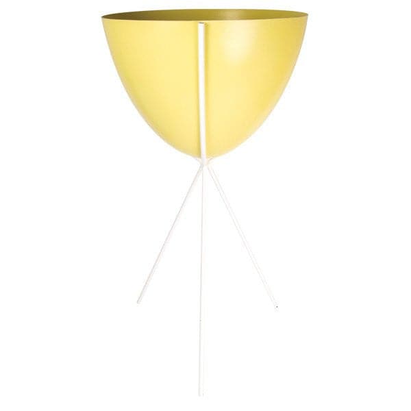 In front of a white background is a yellow colored bullet planter. The planter has a wide top and narrows at the bottom. The planter is held up by a white metal stand. The stand has three white metal legs.