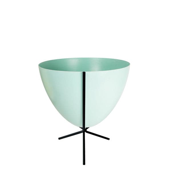 In front of white background is a turquoise planter in a short black metal stand. The bullet planter is wide at the top and narrow at the bottom. The metal stand has three legs. 