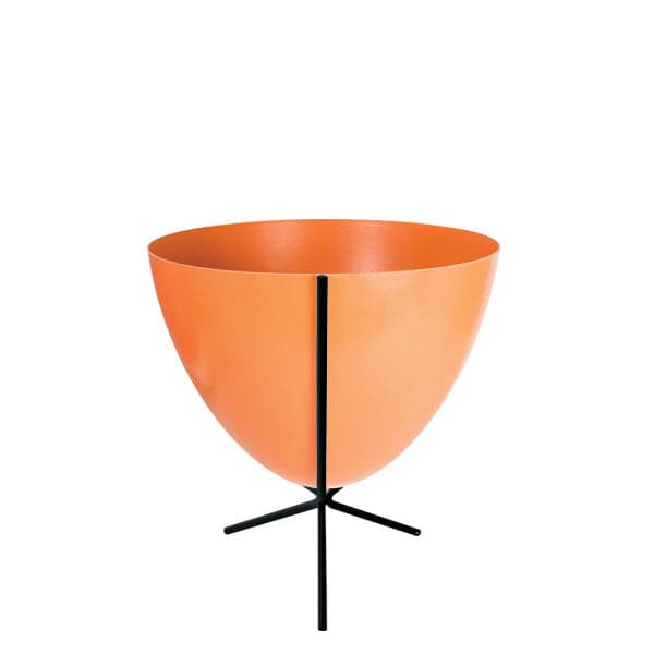 In front of white background is an orange planter in a short black metal stand. The bullet planter is wide at the top and narrow at the bottom. The metal stand has three legs. 